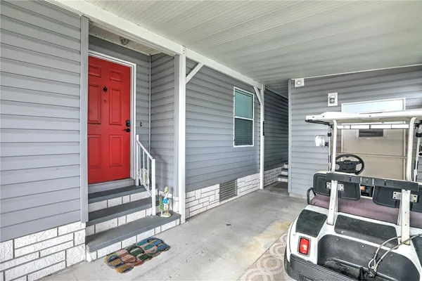 a view of a hallway with chandelier and glass door