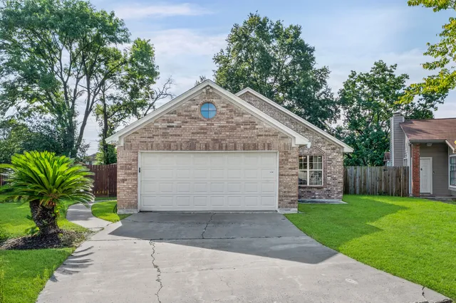 a front view of house with yard and trees around