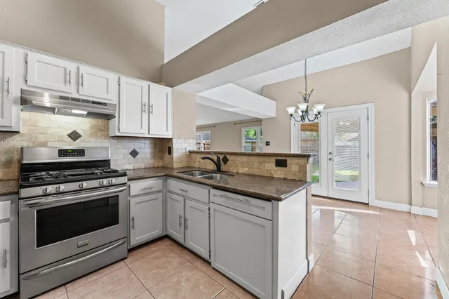a kitchen with stainless steel appliances granite countertop a stove and a sink