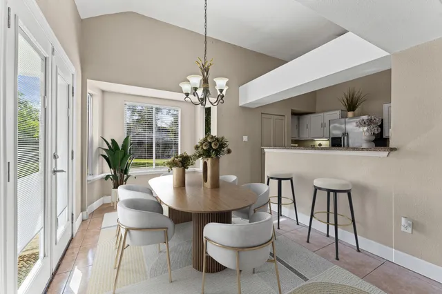 a dining room with furniture a chandelier and wooden floor