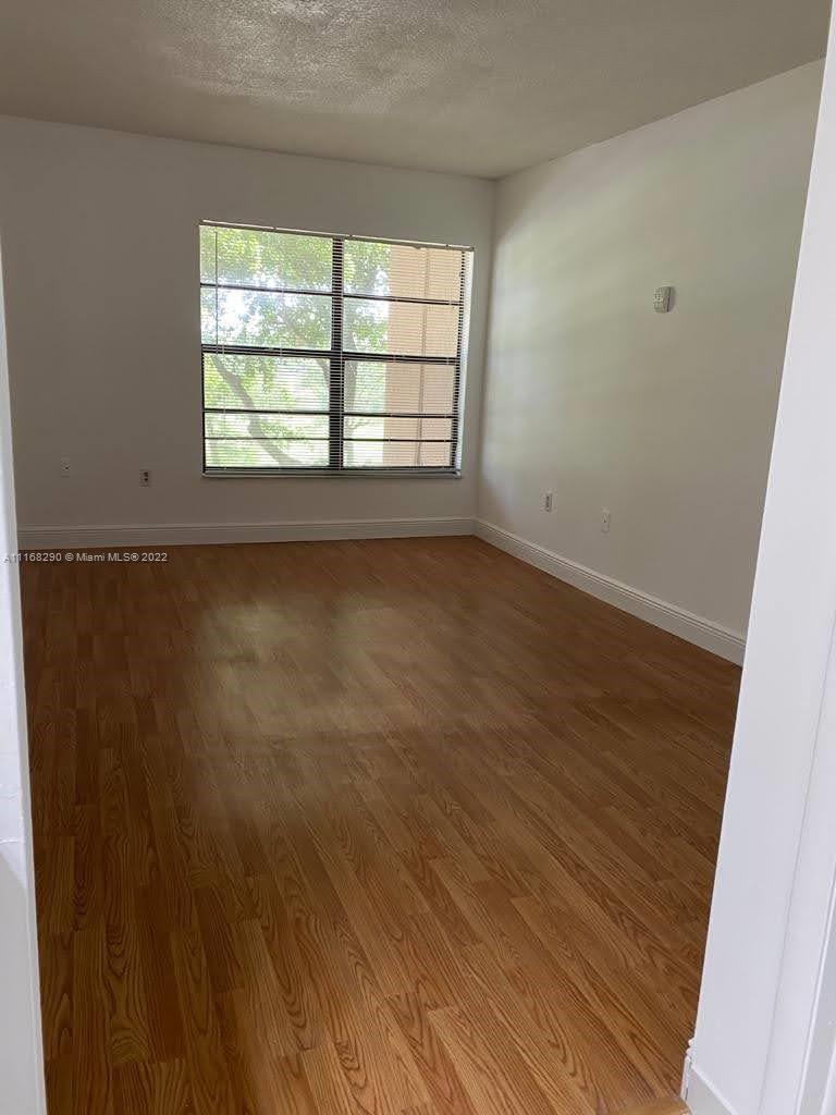 6320 Southwest 138th Court, Unit 308 Miami, FL 33183 - Photo 13 of 25 an empty room with wooden floor and windows