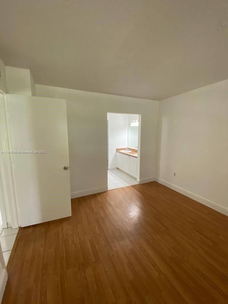 6320 Southwest 138th Court, Unit 308 Miami, FL 33183 - Photo 15 of 25 an empty room with wooden floor and windows