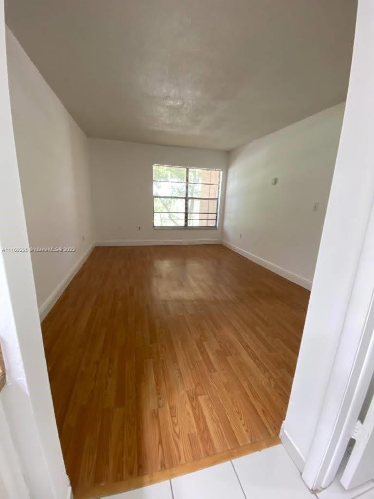 6320 Southwest 138th Court, Unit 308 Miami, FL 33183 - Photo 4 of 25 an empty room with wooden floor and windows