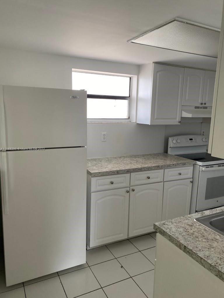 6320 Southwest 138th Court, Unit 308 Miami, FL 33183 - Photo 6 of 25 a kitchen with granite countertop cabinets appliances and a counter space