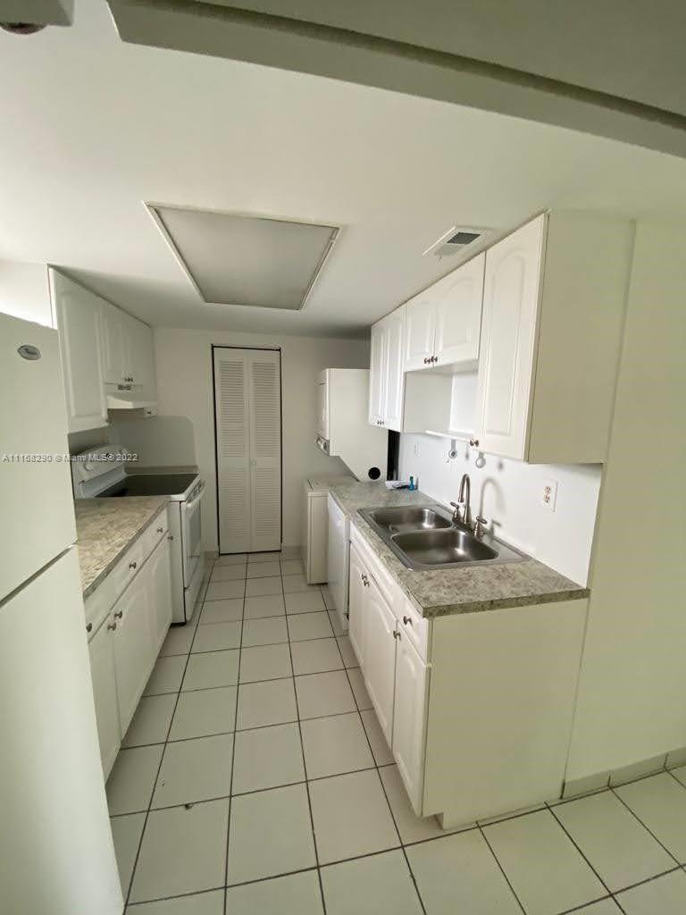 6320 Southwest 138th Court, Unit 308 Miami, FL 33183 - Photo 7 of 25 a kitchen with a sink a stove top oven and cabinets