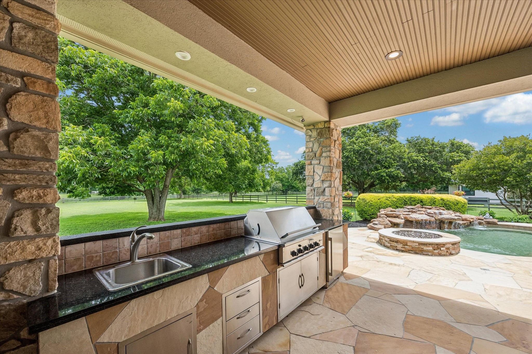 32102 Fulbrook Commons Fulshear, TX 77441 - Photo 37 of 50 Complete with built-in grill, sink, and generous prep space, the outdoor kitchen makes hosting family and friends effortless.