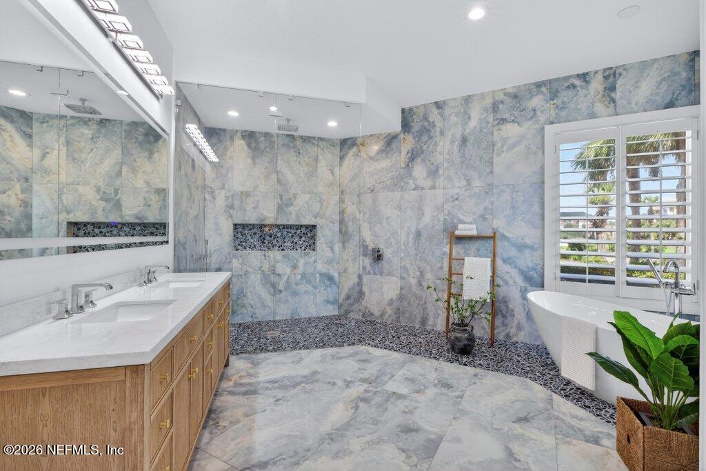 6 Riviera Place Palm Coast, FL 32137 - Photo 33 of 132 a spacious bathroom with a sink a large mirror and a shower