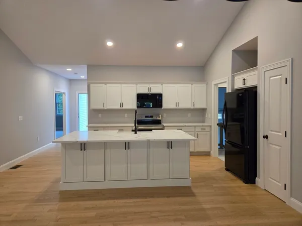 a view of kitchen with stainless steel appliances refrigerator stove microwave and cabinets