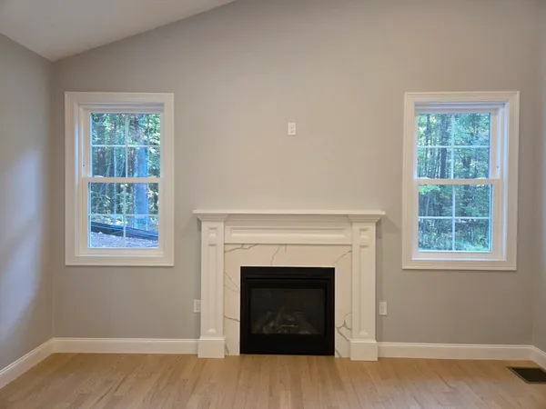 a view of an empty room with a window and fireplace