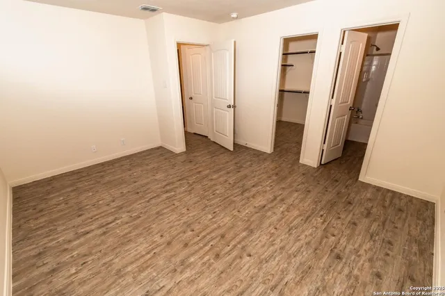 an empty room with wooden floor and entrance