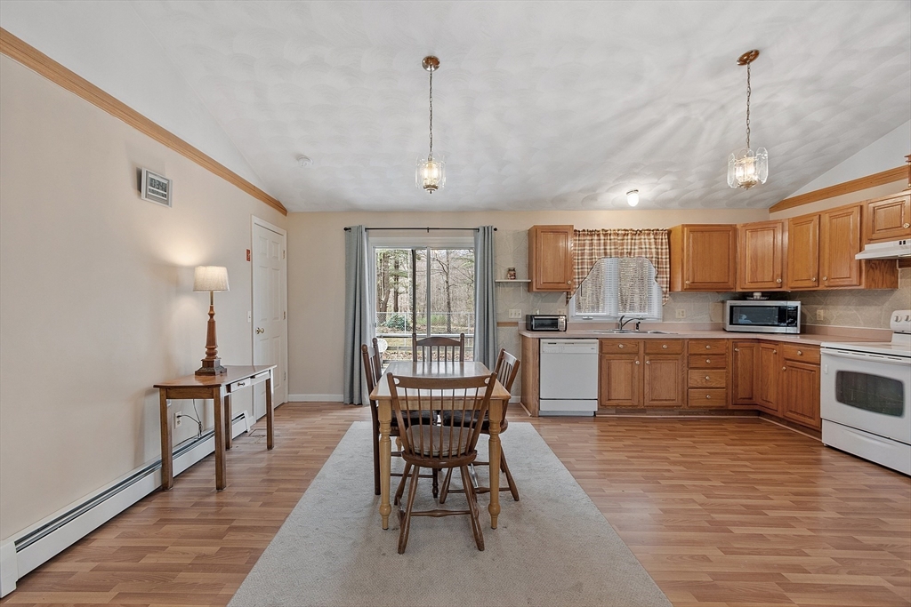 717 Old Petersham Road Barre, MA 01005 - Photo 3 of 40 a kitchen with a table chairs refrigerator and cabinets