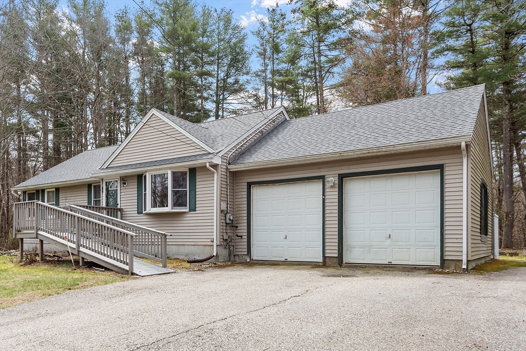 717 Old Petersham Road Barre, MA 01005 - Photo 35 of 40 a front view of a house with a yard garage and wooden fence