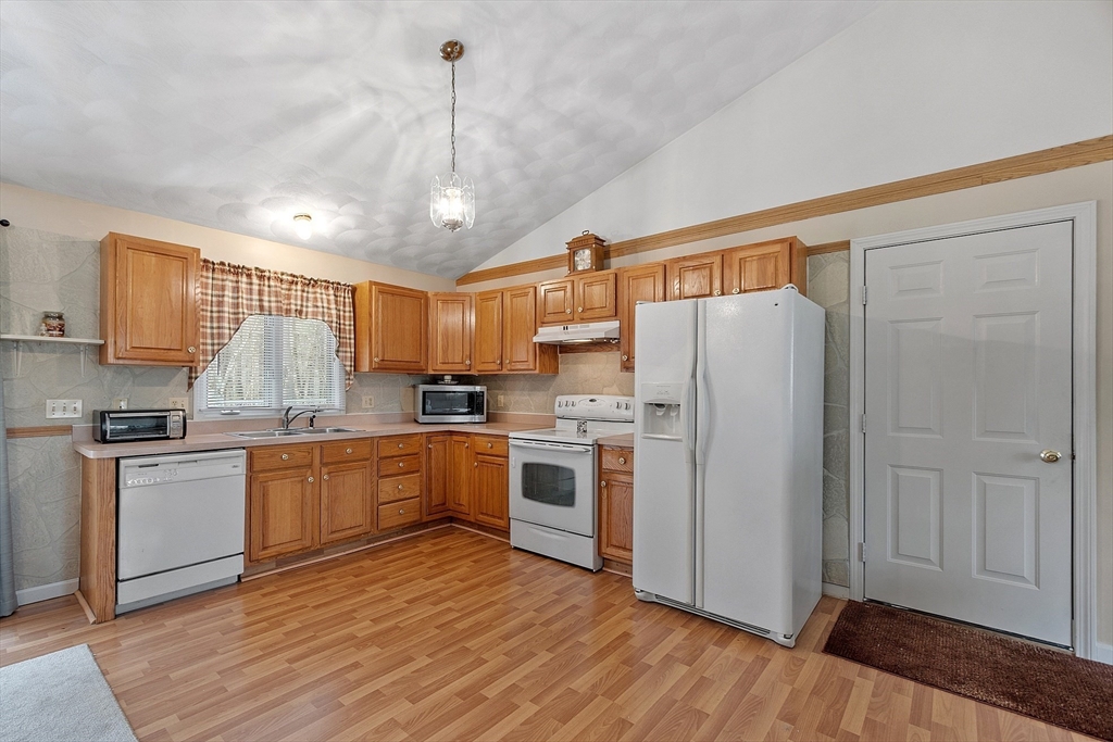 717 Old Petersham Road Barre, MA 01005 - Photo 6 of 40 a kitchen with granite countertop a refrigerator a sink dishwasher a stove and white cabinets with wooden floor