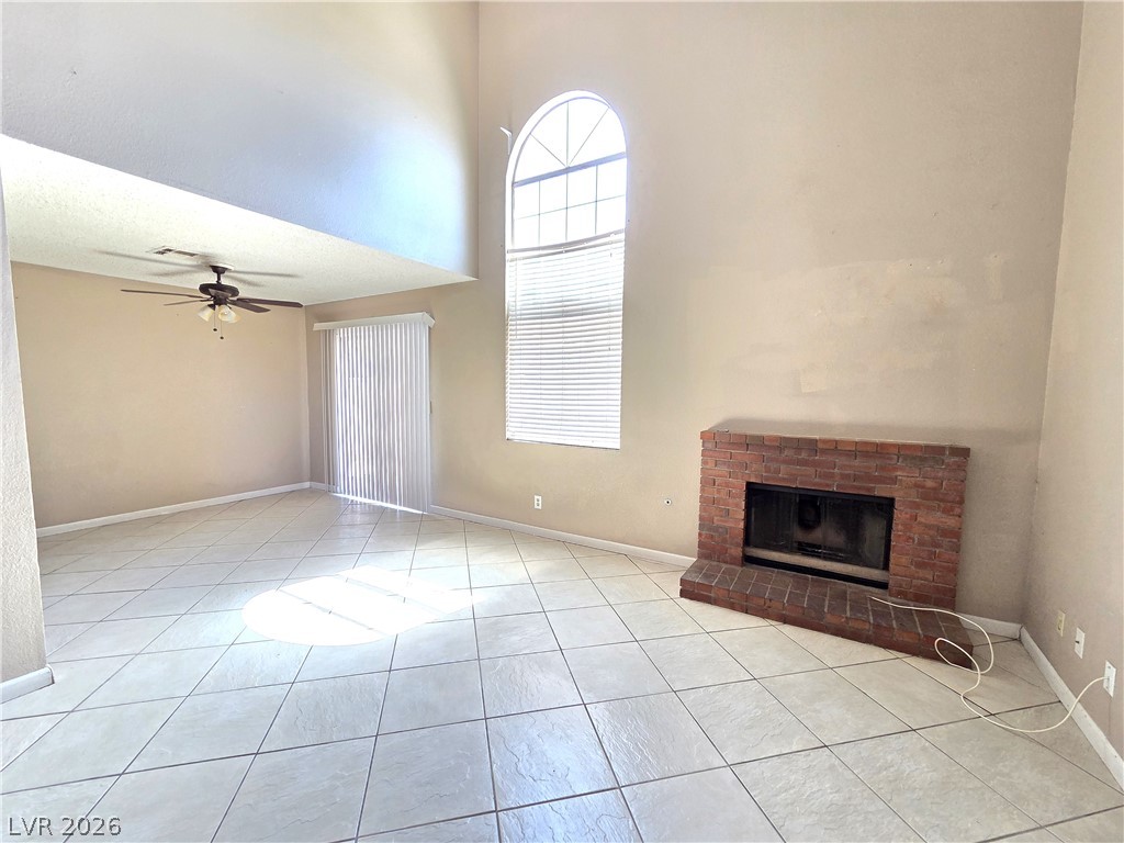 2882 Sandyfalls Way Las Vegas, NV 89142 - Photo 3 of 18 A spacious living room with a soaring ceiling and a classic brick fireplace.