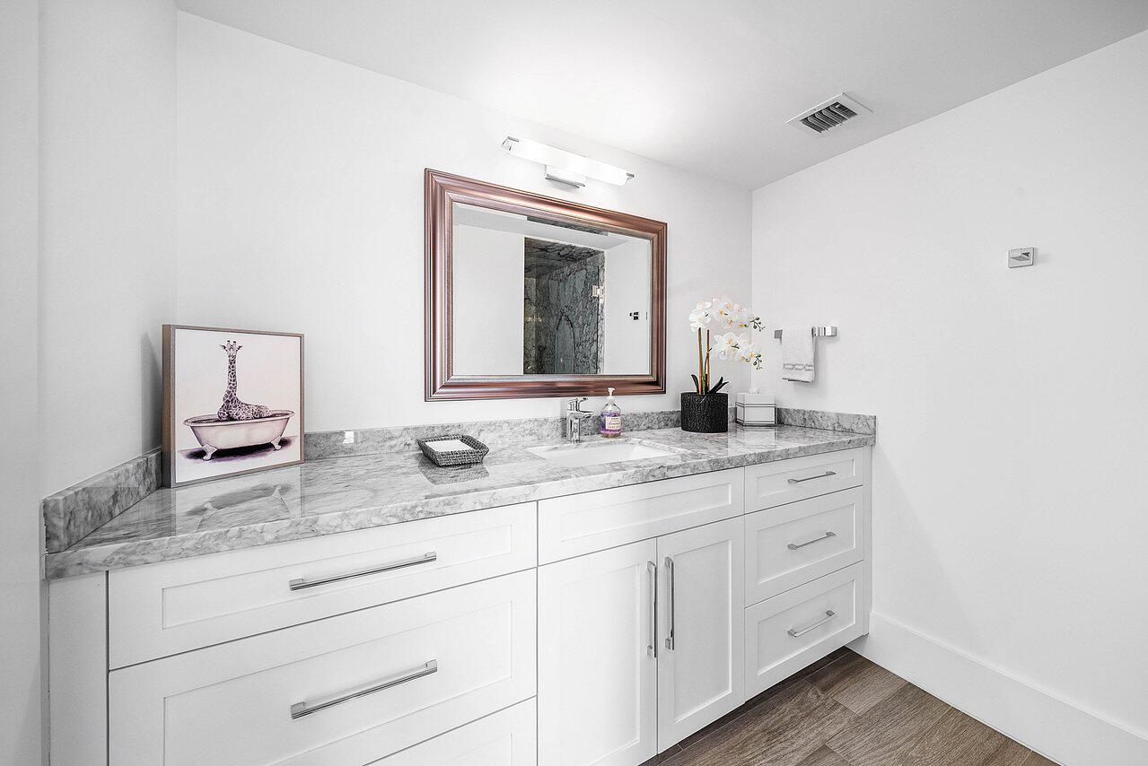 900 Northeast Spanish River Boulevard, Unit 7E Boca Raton, FL 33431 - Photo 18 of 71 a bathroom with a granite countertop sink vanity and mirror