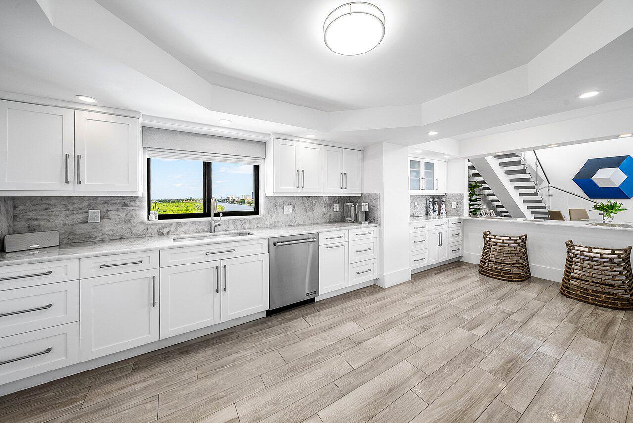 900 Northeast Spanish River Boulevard, Unit 7E Boca Raton, FL 33431 - Photo 21 of 71 a kitchen with stainless steel appliances a sink window and cabinets