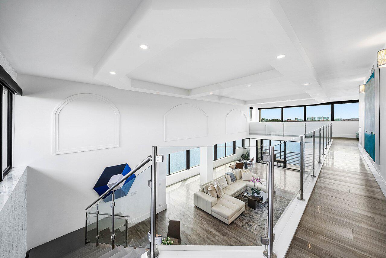 900 Northeast Spanish River Boulevard, Unit 7E Boca Raton, FL 33431 - Photo 25 of 71 a living room with furniture and a table with wooden floor