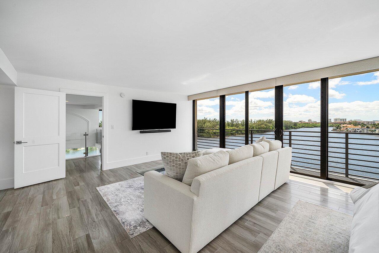 900 Northeast Spanish River Boulevard, Unit 7E Boca Raton, FL 33431 - Photo 31 of 71 a living room with furniture and a flat screen tv