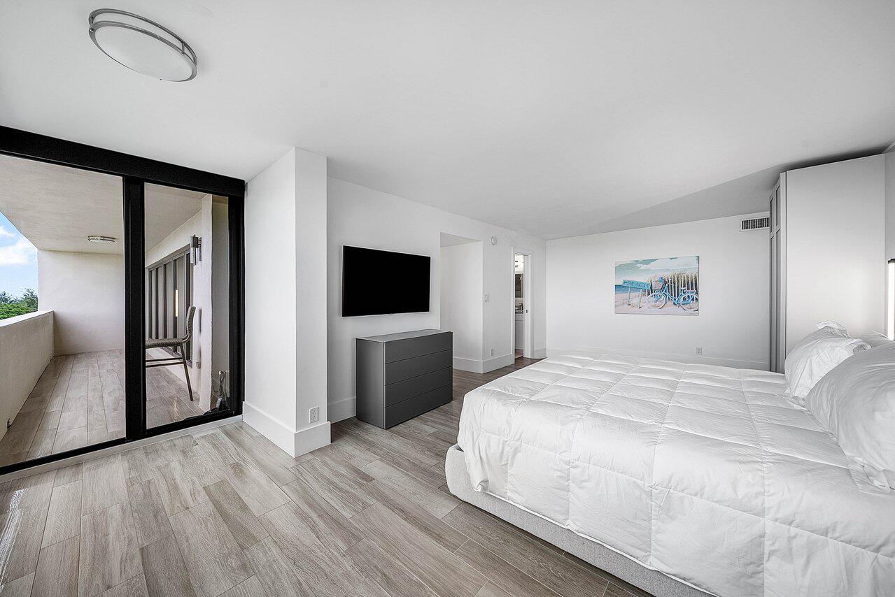 900 Northeast Spanish River Boulevard, Unit 7E Boca Raton, FL 33431 - Photo 44 of 71 a bedroom with a bed and a flat screen tv