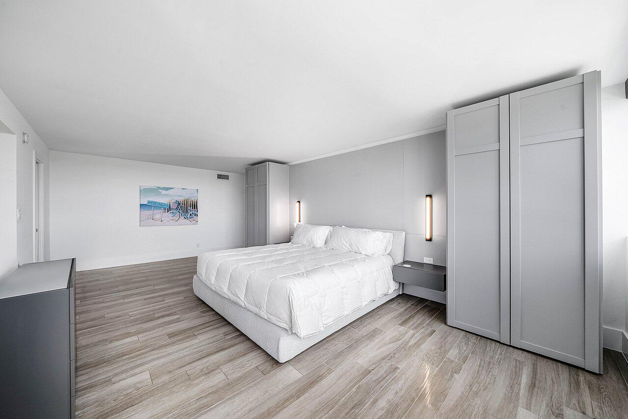 900 Northeast Spanish River Boulevard, Unit 7E Boca Raton, FL 33431 - Photo 45 of 71 a bedroom with a bed and a night stand