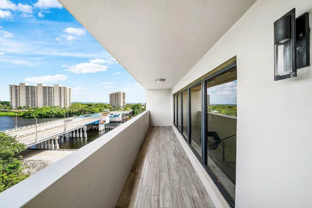 an aerial view of a city with lots of residential buildings ocean and mountain view in back