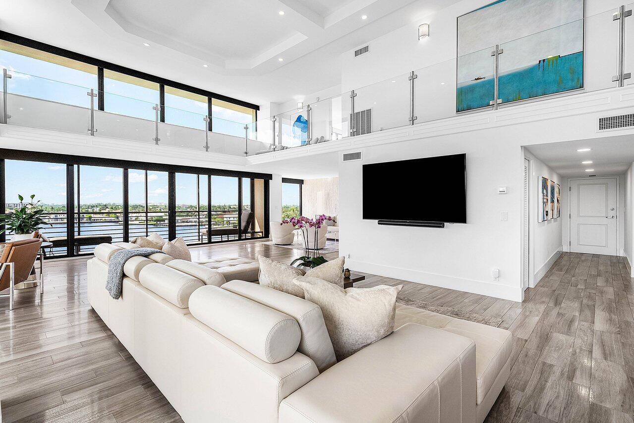 900 Northeast Spanish River Boulevard, Unit 7E Boca Raton, FL 33431 - Photo 6 of 71 a living room with furniture a flat screen tv and a floor to ceiling window