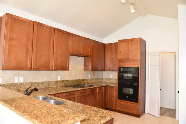 a kitchen with stainless steel appliances granite countertop a refrigerator and a sink