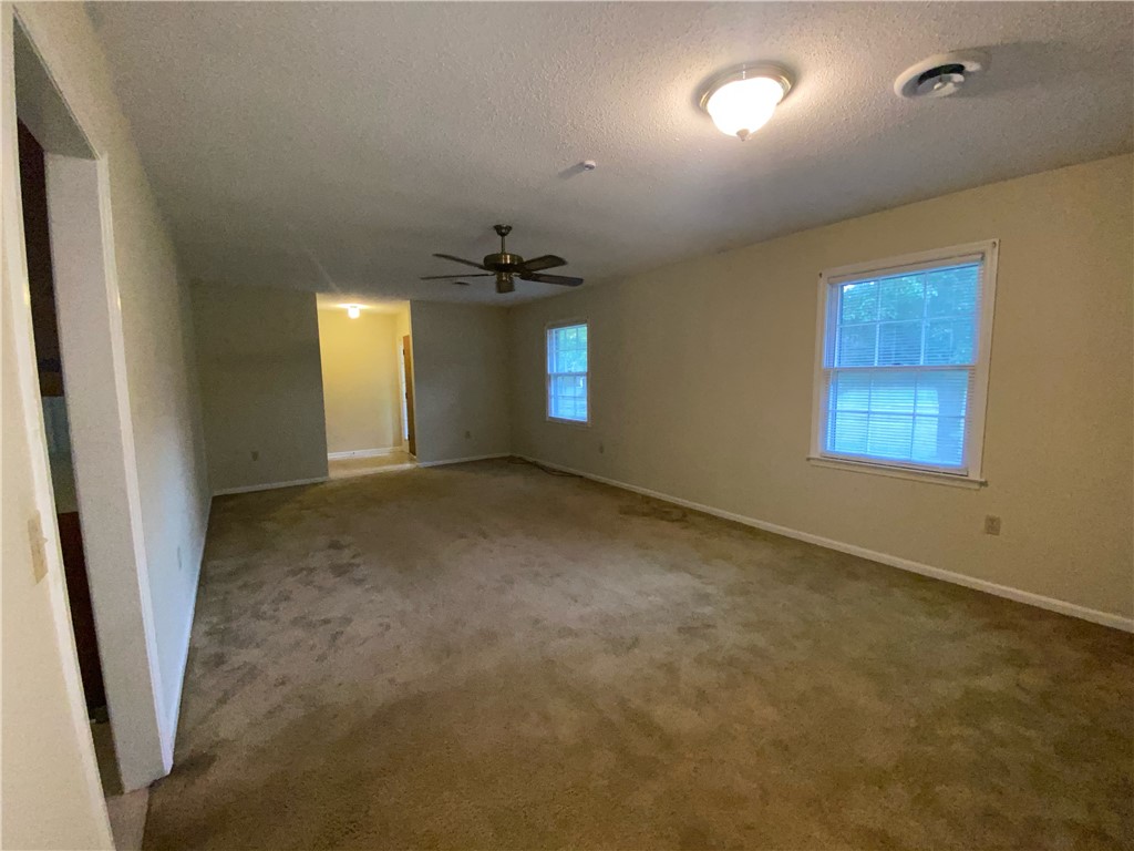 1424 East Calhoun Street Anderson, SC 29621 - Photo 10 of 10 A spacious room featuring carpeted floors and multiple windows providing ambient light.
