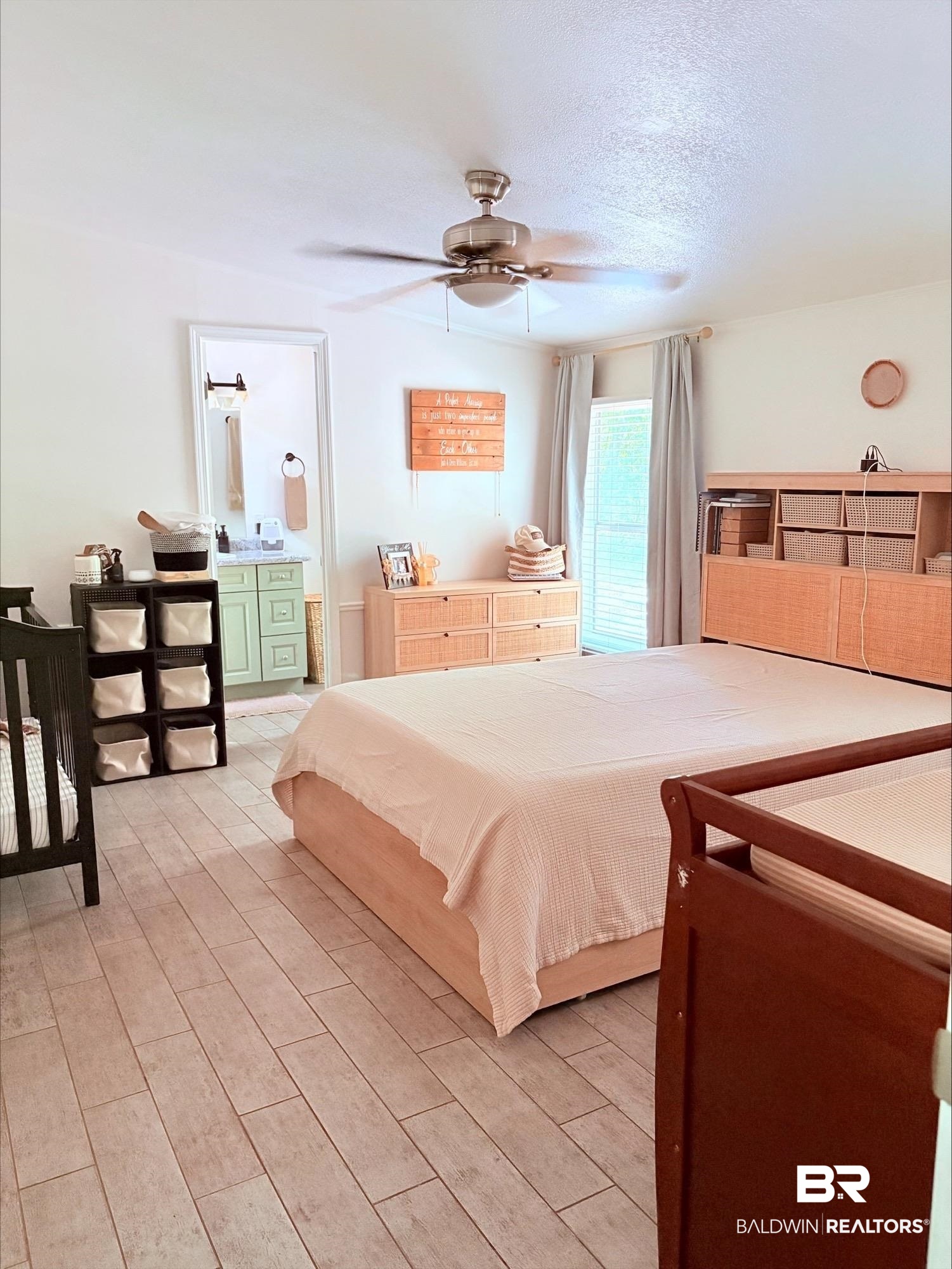 12020 Bay Road West Foley, AL 36535 - Photo 11 of 30 Bedroom with light wood-type flooring, ensuite bath, a textured ceiling, and ceiling fan