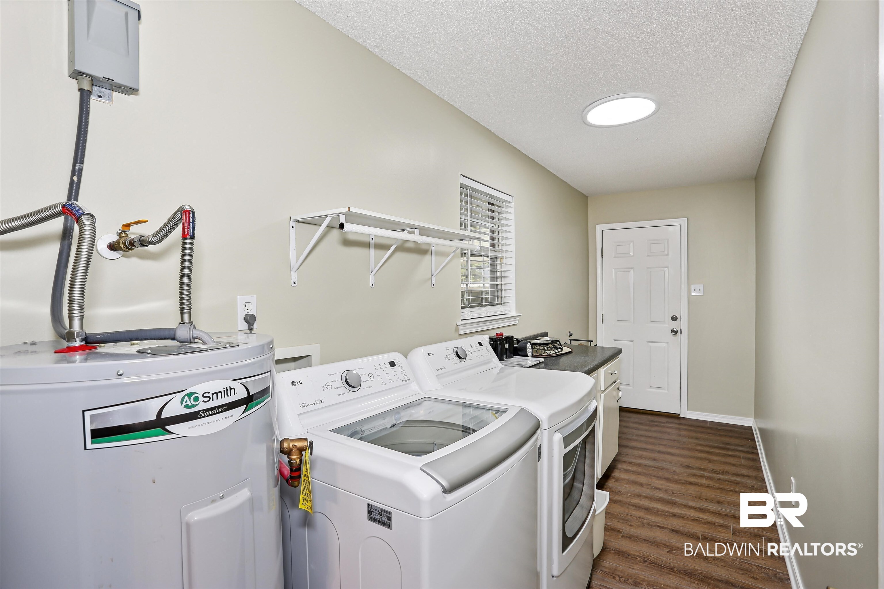 32334 Riverlake Road Seminole, AL 36574 - Photo 25 of 47 Laundry room with water heater, dark wood-type flooring, a textured ceiling, and washer and clothes dryer