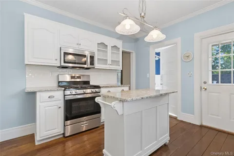 a kitchen with stainless steel appliances granite countertop a stove a sink and a microwave