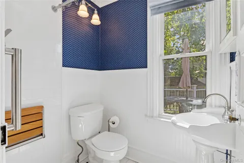 a bathroom with a sink a toilet and a window