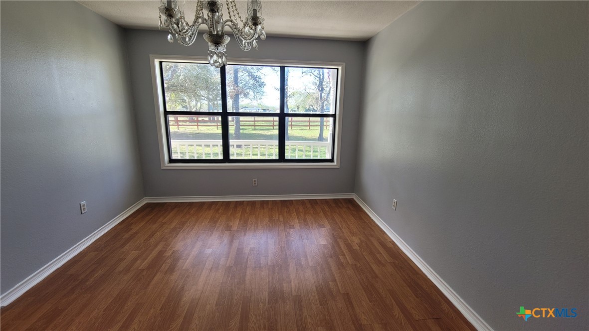 127-129 McAdams Road Goliad, TX 77963 - Photo 9 of 33 an empty room with wooden floor and windows
