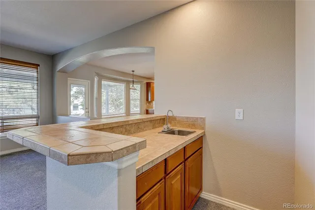 an empty room with windows fireplace and a ceiling fan