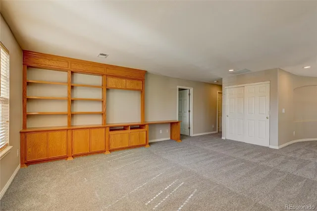 an empty room with a fireplace and windows