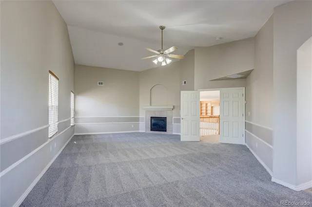 a view of empty room with fireplace and fan