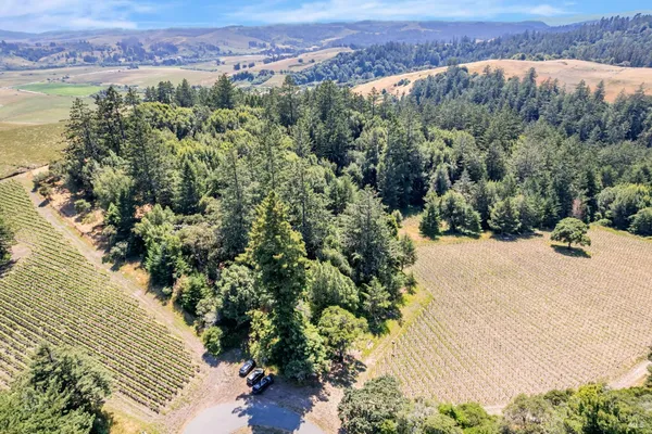 an aerial view of a house with a yard and lake view