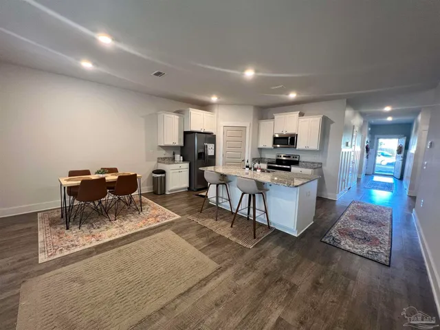 a kitchen with refrigerator and chairs