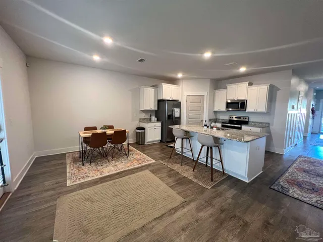 a kitchen with a sink a stove and chairs