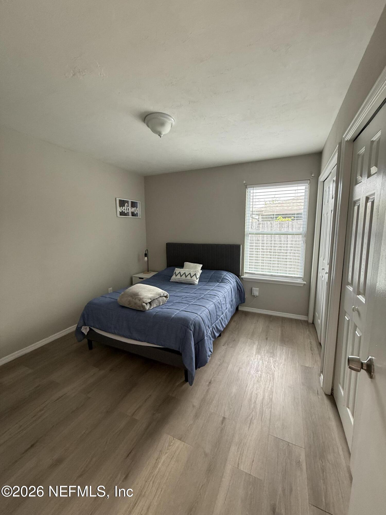2360 Bitternut Way Jacksonville, FL 32246 - Photo 18 of 25 a spacious bedroom with a bed and wooden floor