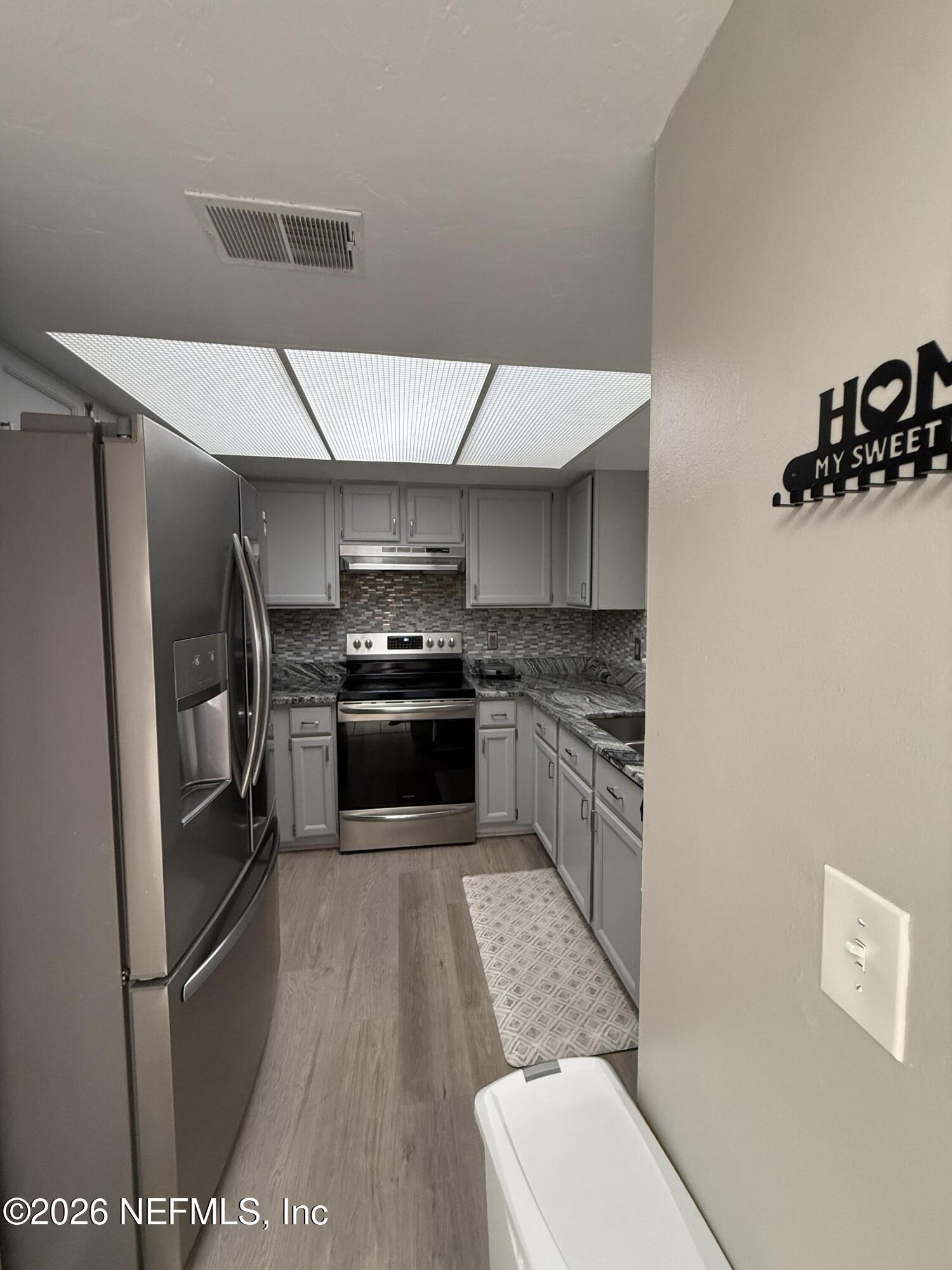 2360 Bitternut Way Jacksonville, FL 32246 - Photo 5 of 25 a kitchen with stainless steel appliances a refrigerator and a stove top oven