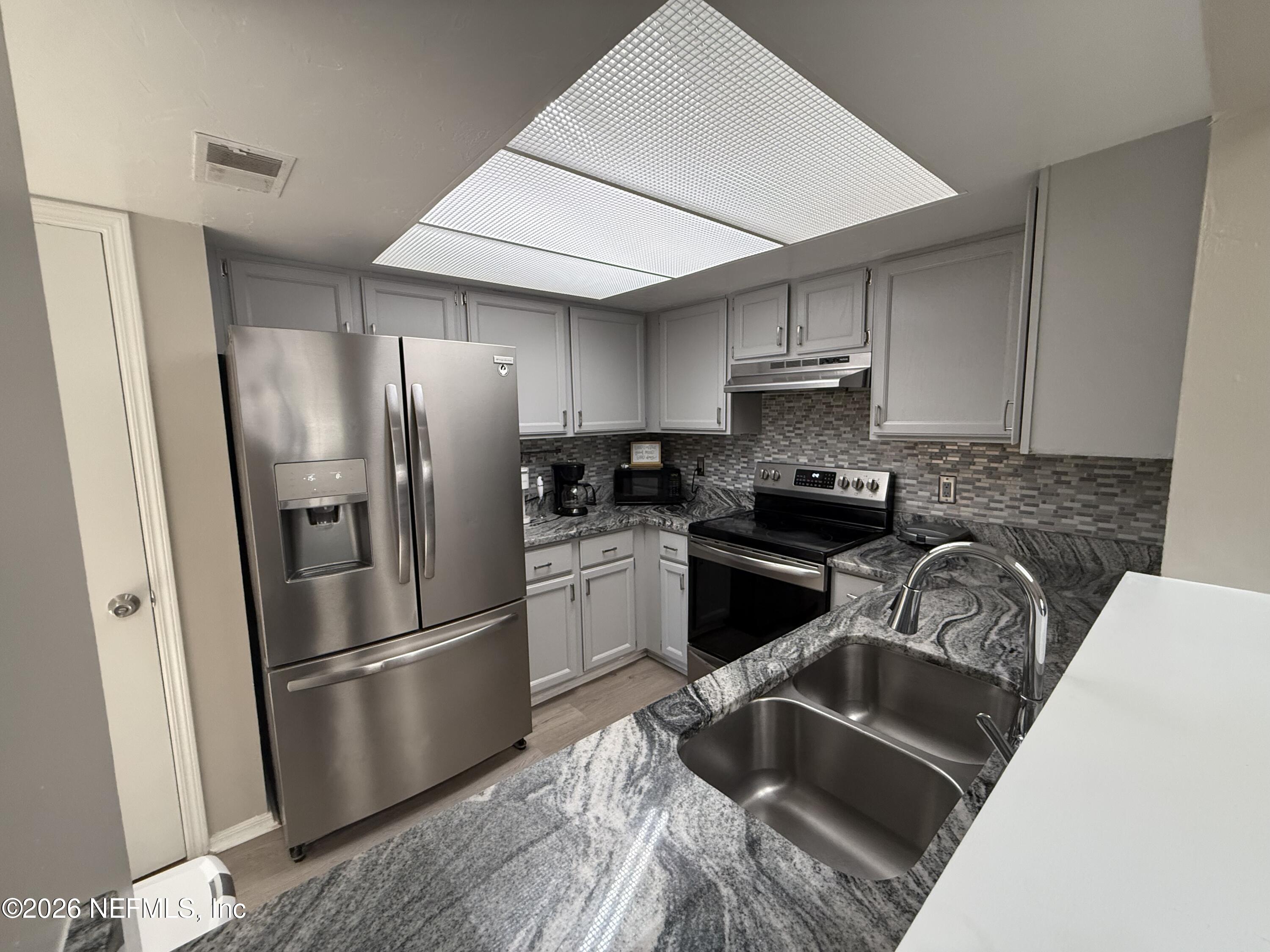 2360 Bitternut Way Jacksonville, FL 32246 - Photo 6 of 25 a kitchen with granite countertop a refrigerator stove and sink