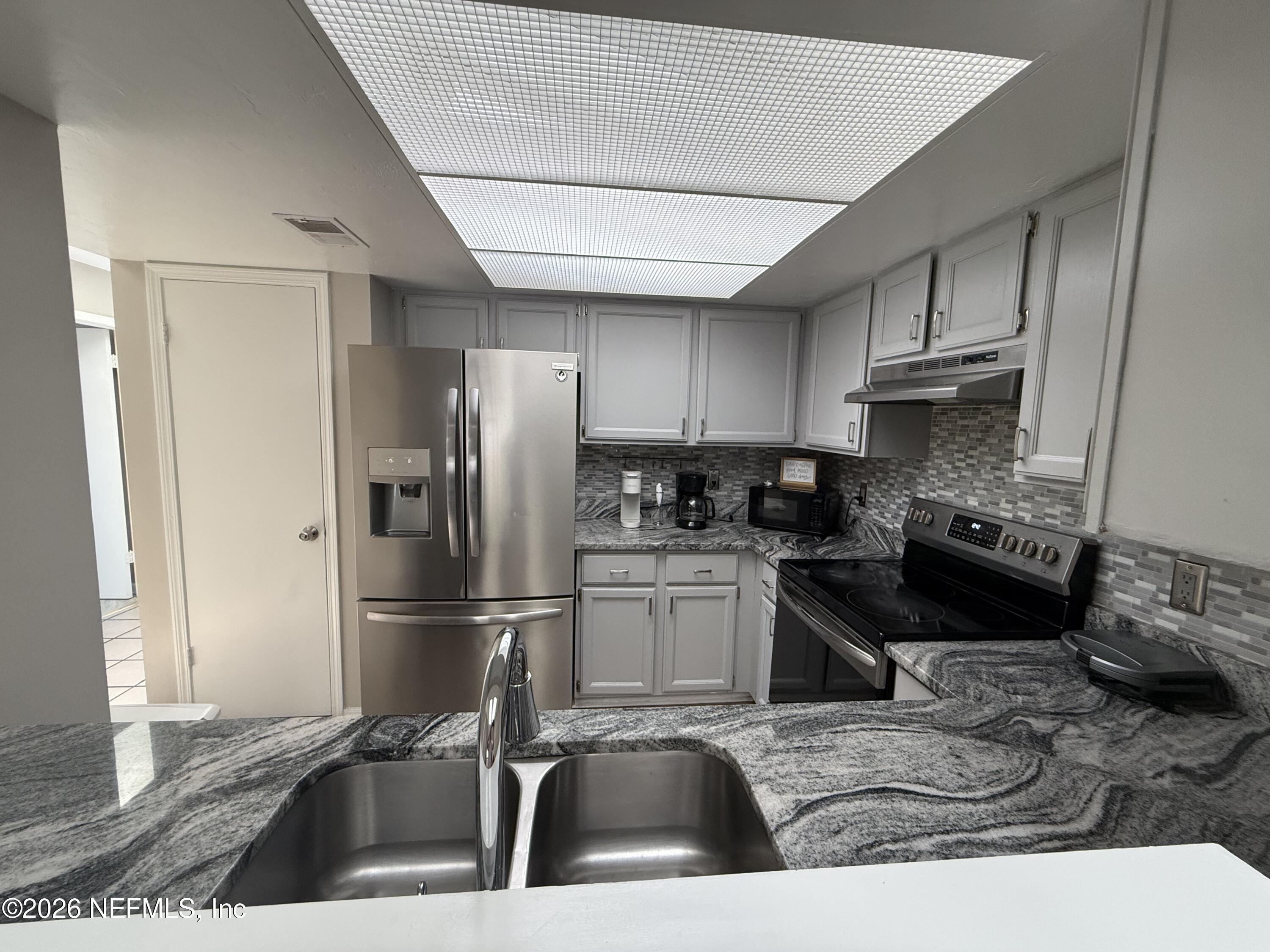 2360 Bitternut Way Jacksonville, FL 32246 - Photo 7 of 25 a kitchen with stainless steel appliances granite countertop a sink stove and refrigerator