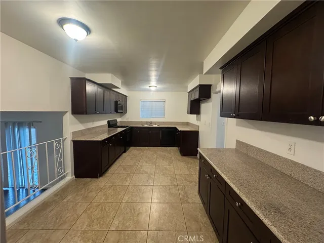 a large kitchen with a large counter top space appliances and cabinets