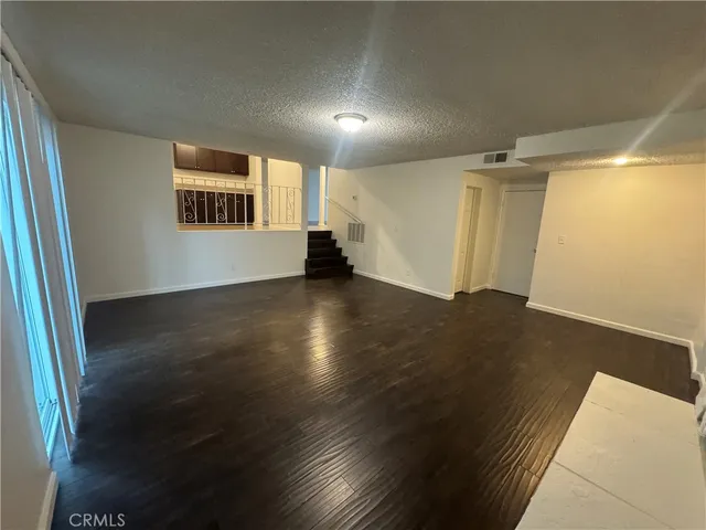 en empty room with wooden floor and windows