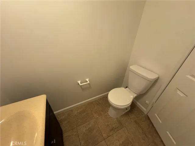 a bathroom with a granite countertop toilet and a sink