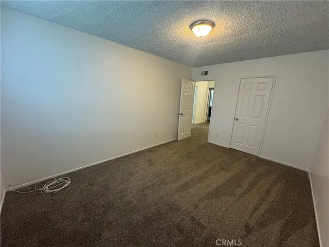 an empty room with a chandelier fan and a window