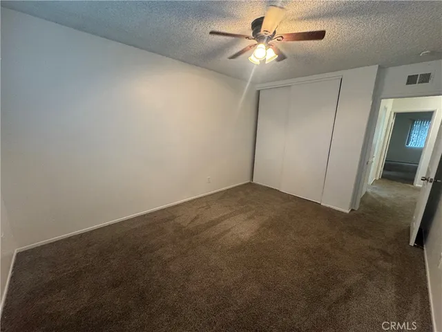 an empty room with a window and a fan