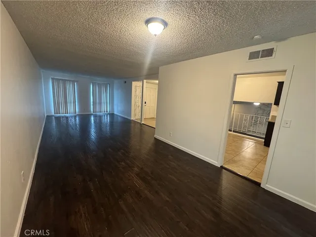 an empty room with wooden floor and entrance