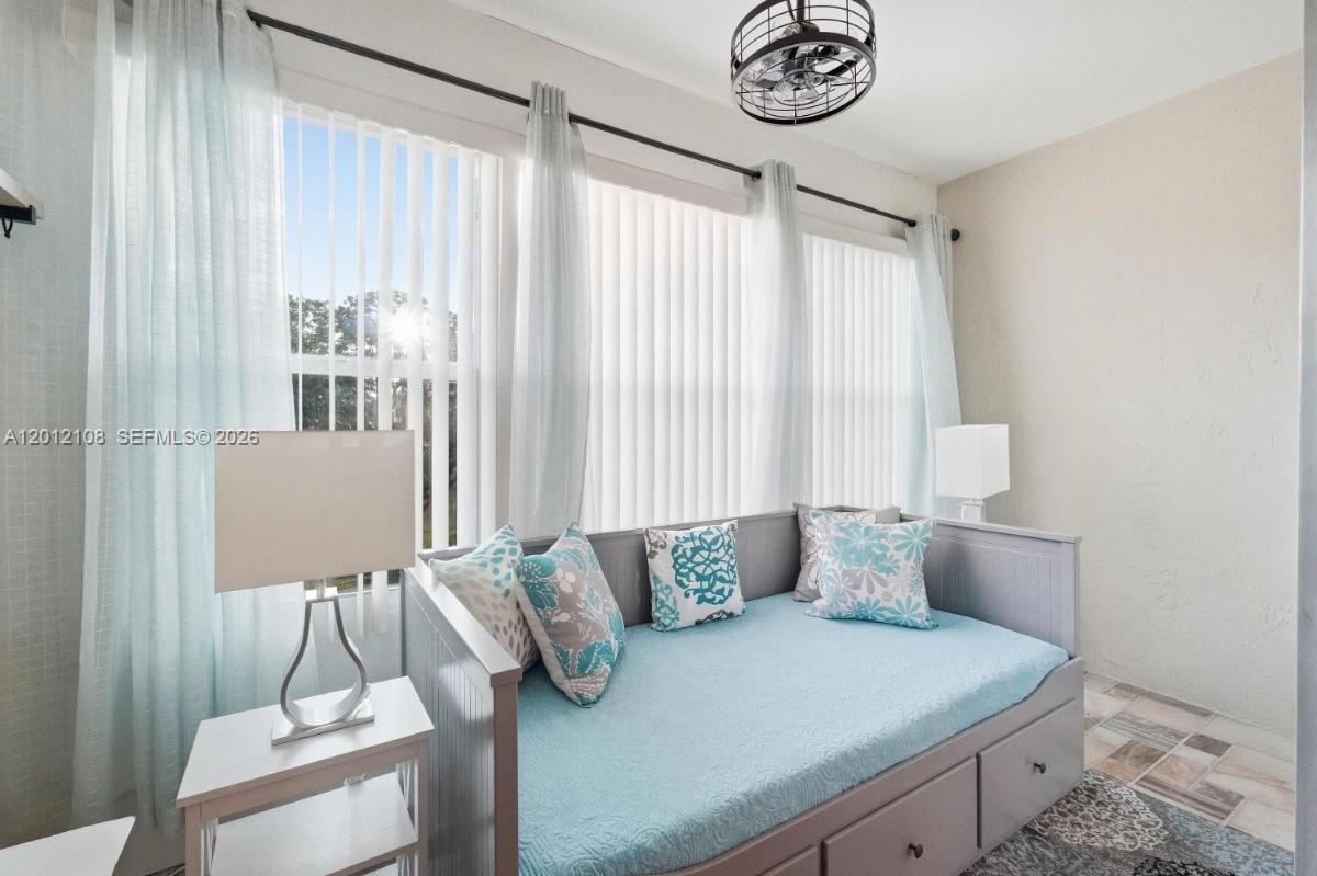 8826 West McNab Road, Unit 304 Tamarac, FL 33321 - Photo 11 of 22 a bedroom with a bed and a chandelier